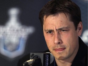 In 2011, then Tampa Bay Lightning coach Guy Boucher listens to a reporter's question during a media availability in Boston. Boucher has been hired as the new head coach of the Ottawa Senators.
