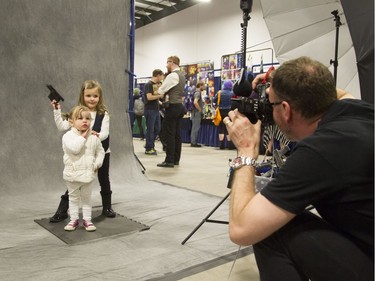 Han Solo and Princess Leia, aka Maggie and Molly Ryan, 4 and 2, have their photo taken by Richard Dufault at Comiccon on Friday. (Bruce Deachman, Ottawa Citizen)