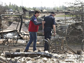 Prime Minister Justin Trudeau, left, and Fort McMurray Fire Chief Darby Allen look over the devastation during a visit to Fort McMurray, Alta., on Friday, May 13, 2016.