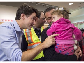 Canadian Prime Minister Justin Trudeau greets 16-month-old Madeleine Jamkossian, right, and her father Kevork Jamkossian, during their arrival at Pearson International airport, in Toronto, on Friday, Dec. 11, 2015. We've accepted far more refugees than the United States, writes Angelina Chapin.