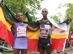 Koren Jelela (L) and Dino Sefir (R) of Ethiopia pose after finishing 1st in the women's and men's category in the Scotiabank Ottawa Marathon, held in downtown Ottawa, during the Tamarack Ottawa Race Weekend, on May 29, 2016.