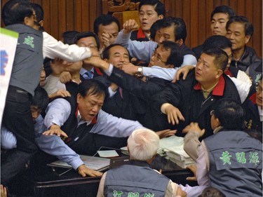 Legislators fight their way towards Parliament speaker Wang Jin-pyng's microphone during a disruption at the Parliament Taipei 19 January 2007.  Pushing, shoving and fighting between rival legislators disrupted parliament before voting on a controversial bill on the island's top election body.