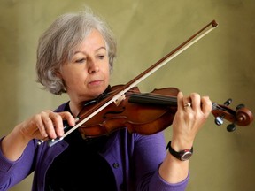 Liz Payne practices her violin at her Ottawa home.