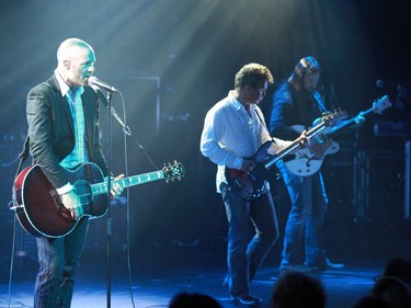 Gord Downie belts out a song with Gord Sinclair on bass (middle) and Rob Baker on guitar (right) on tour at the National Arts Centre in 2009.