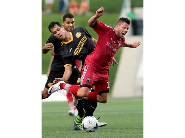 Ottawa's Carl Haworth gets on top of the ball, ahead of Fort Lauderdale's Luis Felipe Fernandes, but suffers a fall.