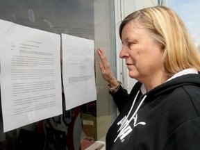 President of Ottawa Neighbourhood Services, Patricia Lemieux, reads the eviction notice on the door.