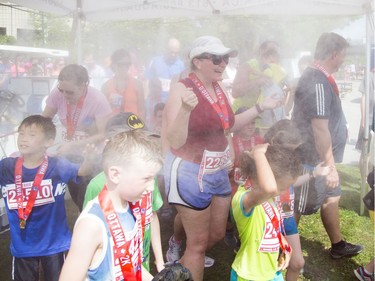 Runners cool off under a cool mist after finishing the 2K race.