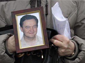 n this Monday, Nov. 30, 2009, file photo a portrait of lawyer Sergei Magnitsky who died in jail, is held by his mother Nataliya Magnitskaya, as she speaks during an interview with the AP in Moscow.