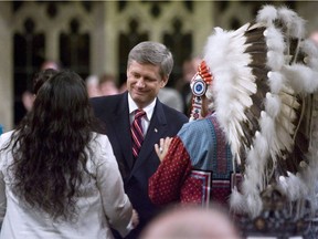 Assembly of First Nations Chief Phil Fontaine, right, watches as Canadian Prime Minister Stephen Harper thanks Beverley Jacobs, head of the Native Women's Association of Canada, after she responded to the government's apology for more than a century of abuse and cultural loss involving Indian residential schools at a ceremony in the House of Commons on Parliament Hill in Ottawa, Wednesday, June 11, 2008.