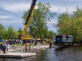 The Queen Elizabeth, a 100% electric vessel to be operated by Ottawa Boat Cruises starting this year, is lowered into the water of the Gatineau River for the first time for testing Thursday.