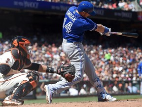 Justin Smoak #14 of the Toronto Blue Jays hits an rbi single scoring Edwin Encarnacion #10 against the San Francisco Giants in the top of the eighth inning at AT&T Park on May 11, 2016 in San Francisco, California.