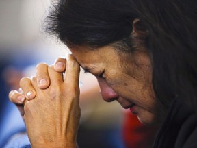Fort McMurray wildfire evacuee Gloria Trottier prays during a service at the Word of Faith Family Church, in Lac la Biche, Alberta, Sunday May 8, 2016.