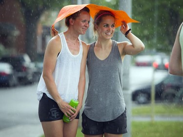 Two young women try to shield themselves from the rain during the 10K.