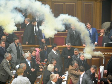 A smoke bomb is thrown during a parliament sitting in Kiev on April 27, 2010. Fighting broke out and smoke bombs and eggs were thrown Tuesday as Ukraine's parliament erupted into chaos as it ratified a bitterly controversial deal with Russia extending the lease of a key naval base. The deal signed last week by Russian President Dmitry Medvedev and his Ukrainian counterpart Viktor Yanukovych had been slammed by the pro-Western Ukrainian opposition as a historic surrender of sovereignty. Deputies also started fighting over a massive Ukrainian flag in the middle of the chamber, twisting and distorting the yellow and blue banner as smoke continued to billow in the chamber.