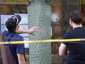 Workers examine shattered glass at the seen of a shooting at the EDC building at O'Connor and Slater on Monday, May 23, 2016.