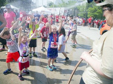 Young runners cool off under a hose Laura Tobin was spraying after the 2K.