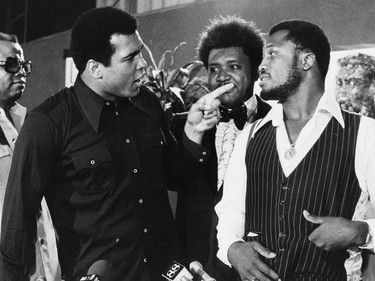 FILE - In this July 17, 1975, file photo, sports promoter Don King stands between Muhammad Ali, left, the heavyweight champion, and Joe Frazier in New York. Ali, the magnificent heavyweight champion whose fast fists and irrepressible personality transcended sports and captivated the world, has died according to a statement released by his family Friday, June 3, 2016. He was 74.