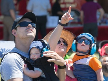 A family watches the acrobatics as Vintage Wings of Canada put on their annual Wings Over Gatineau Airshow at the Gatineau Airport.