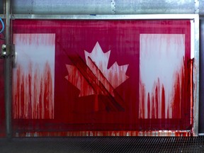 A silkscreen frame for a Canadian flag is pressure washed after being used. (Bruce Deachman, Ottawa Citizen)