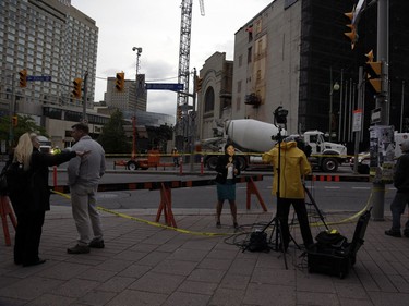 A television news crew reports from the scene as workers behind them began to fill in the sinkhole that opened up this morning just east of the intersection of Rideau Street and Sussex Drive, which caused a gas leak and building evacuations, on June 8, 2016. (David Kawai)
