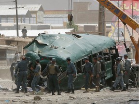 Afghan security forces inspect the site of a suicide attack on the outskirts of Kabul, Afghanistan, Thursday, June 30, 2016. A twin suicide attack on a convoy of buses carrying police cadets killed 37 people and wounded 40 others on Thursday, an Afghan official said.