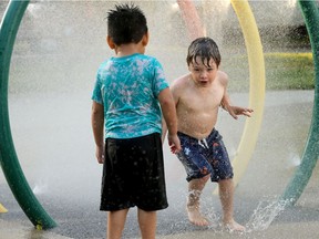 Angel Castillo, 3, left, seems to be weighing his options as he watches another boy come through a chilly ring of water at the Westfest mini park.