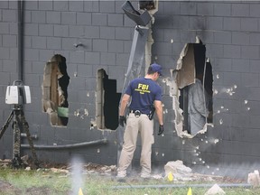 An FBI agent examines the damaged rear wall of the Pulse Nightclub where Omar Mateen killed 49 people on Sunday.