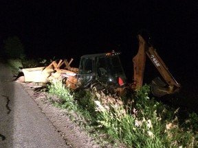 Man arrested early Wednesday asleep at controls of this backhoe, stuck in a ditch.