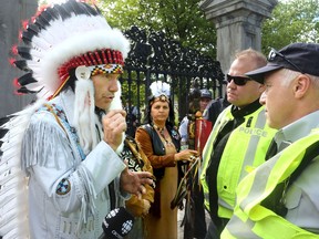 Billy Carle, grand chief of the Confederation of Aboriginal People of Canada, has a discussion with RCMP officers outside Rideau Hall on Monday, June 6, 2016.