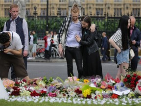 A couple mourns in front of a floral tributes and candles laid in remembrance of slain Labour MP Jo Cox in London. Cox was a 41-year-old former aid worker also known for her advocacy for Syrian refugees.