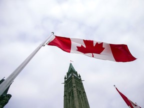 A Canadian flag flies in front of the peace tower on Parliament Hill in Ottawa, Canada on December 4, 2015, as part of the ceremonies to the start Canada's 42nd parliament .