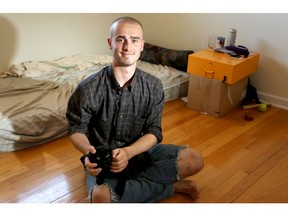 David Cook, 21, unemployed and sharing an apartment with friends in Ottawa, is pictured in his bedroom with his cat, Cole.  JULIE OLIVER/POSTMEDIA