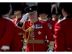 Governor General David Johnston salutes the flags as he passes infront of the flag party during an inspection of the Ceremonial Guard at Rideau Hall Monday June 23, 2014 in Ottawa.