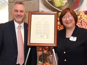 Deputy Mayor Mark Taylor with Ottawa Quota Club president Willy Lee, alongside an official Quota International of Ottawa Day proclamation from Mayor Jim Watson, at the service club's 70th anniversary celebration dinner, held at Algonquin College's Restaurant International on Monday, June 27, 2016.