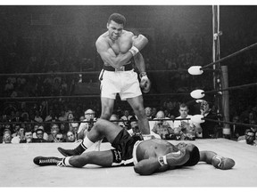 In this May 25, 1965, file photo, heavyweight champion Muhammad Ali, then known as Cassius Clay, stands over challenger Sonny Liston.