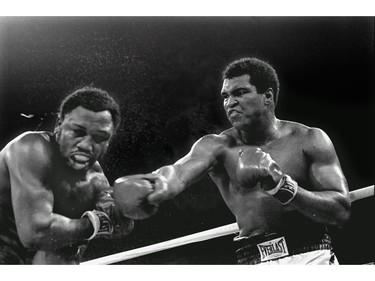 FILE - In this Oct. 1, 1975, file photo, spray flies from the head of Joe Frazier as Muhammad Ali connects with a right in the ninth round of their title fight in Manila, Philippines, Ali won the fight on a decision to retain the title. The two fought three times, including two of the most famous matches ever.