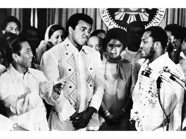 FILE - In this Sept. 18, 1975, file photo, Philippines President Ferdinand Marcos, left, applauds as challenger Joe Frazier, right, makes some remarks about world champion Muhammad Ali, second from left, during their call on Marcos at the Malacanang Palace in Manila, Philippines.  Ali, the magnificent heavyweight champion whose fast fists and irrepressible personality transcended sports and captivated the world, has died according to a statement released by his family Friday, June 3, 2016. He was 74.