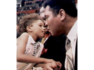 (FILES) This file photo taken on December 16, 1994 shows Legendary US boxer Muhammad Ali is kissed by a young Ecuadoran girl at the Quito's Ruminahui Coliseum, Ecuador.  Boxing icon Muhammad Ali died on Friday, June 3, a family spokesman said in a statement. "After a 32-year battle with Parkinsons disease, Muhammad Ali has passed away at the age of 74," spokesman Bob Gunnell said.  /