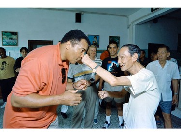 (FILES) This file photo taken on September 01, 1994 shows Boxing great Muhammad Ali receiving a punch from a 79 old "sparring-partner" during a visit in a old people's home in Macau. Boxing legend Muhammad Ali, dies at 74. The former heavyweight world champion was hospitalized on Thursday at a Phoenix, Arizona, hospital with a respiratory issue, which US media reported was complicated by his Parkinson's disease.  /