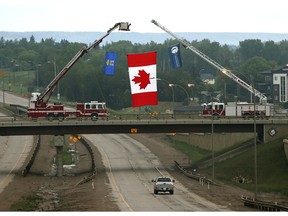 A Canadian flag, hanging from a bridge on Alberta Highway 63 at the south entrance to Fort McMurray, welcomes residents back to their city on June 3, 2016.