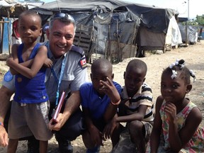 Gatineau Constable Pierre Lanthier and Haitian kids in a camp for people displaced by the 2010 earthquake. credit Gatineau Police