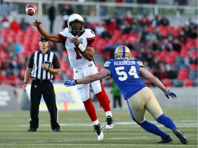 Henry Burris (L) of the Ottawa Redblacks throws as he is defended by Andrew Robinson of the Winnipeg Blue Bombers during first half action at TD Place in Ottawa, June 13, 2016.