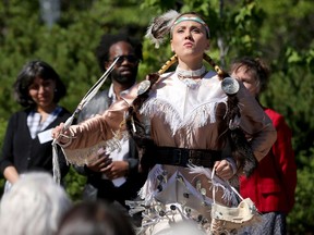 Josee Bourgeois, a jingle dress dancer from Pikwakanagan, performs on the lawn of city hall with four drummers following speeches. Two Algonquin Anishinaabe flags were raised and a commemorative stone artwork was unveiled at Ottawa City Hall Tuesday as part of Aboriginal Awareness Day.