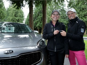 Brooke Henderson of Smiths Falls, Ont., and her sister/caddie Brittany pose next to a Kia after Brooke made a hole in one on the 13th hole during the first round of the KPMG Women's PGA Championship at the Sahalee Country Club on June 9, 2016 in Sammamish, Washington.