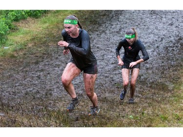 Kyra Lee (L) and Jenny Lee make their way up a hill as the Mud Hero Ottawa 2016 continued on Sunday at Commando Paintball located east of Ottawa.