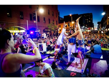 From left, Marie-Julie Côté, Sara Campbell and Andrée-Anne Ouellet played around before a yoga class on Bank Street during Glowfair Festival Friday June 17, 2016.