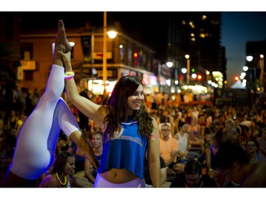 L-R Marie-Julie Côté (upside-down) and Sara Campbell played around before a yoga class on Bank Street during Glowfair Festival Friday June 17, 2016.