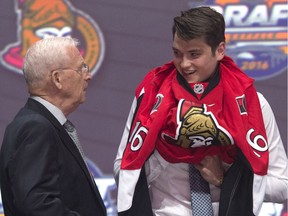 Logan Brown talks with the Senators' Bryan Murray as he pulls on his jersey after being selected 11th overall.