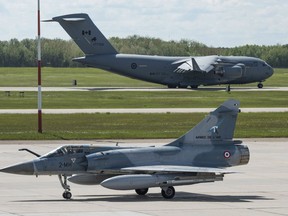 A French Air Force M2000 Mirage fighter returns from a flight as a Royal Canadian Air Force CC-177 Globemaster takes off from the runway behind during Exercise MAPLE FLAG at 4 Wing Cold Lake, Alberta on May 31, 2016.

Photo: Cpl Ian Thompson, 4 Wing Imaging
CK01-2016-0510-027
~
Un chasseur M2000 Mirage de l’Armée de l’air française est de retour après avoir effectué un vol, et un avion CC-177 Globemaster de l’Aviation royale canadienne décolle derrière, au cours de l’exercice MAPLE FLAG,  à la 4e Escadre Cold Lake, en Alberta, le 31 mai 2016. 

Photo : Cpl Ian Thompson, Services d’imagerie de la 4e Escadre
CK01-2016-0510-027