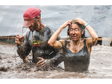 Marie-France Marcoux (R) tries to clear the mud from her face as the Mud Hero Ottawa 2016 continued on Sunday at Commando Paintball located east of Ottawa.